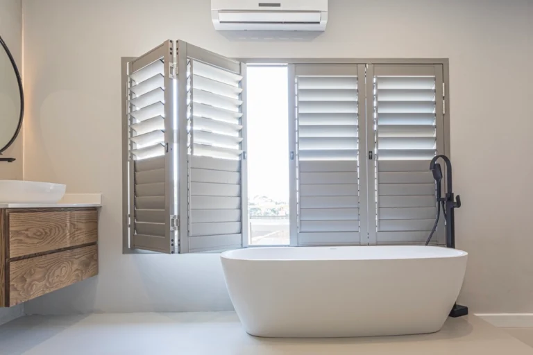 Shutters beside a freestanding bath